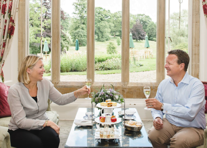 A happy couple enjoying champagne and afternoon tea